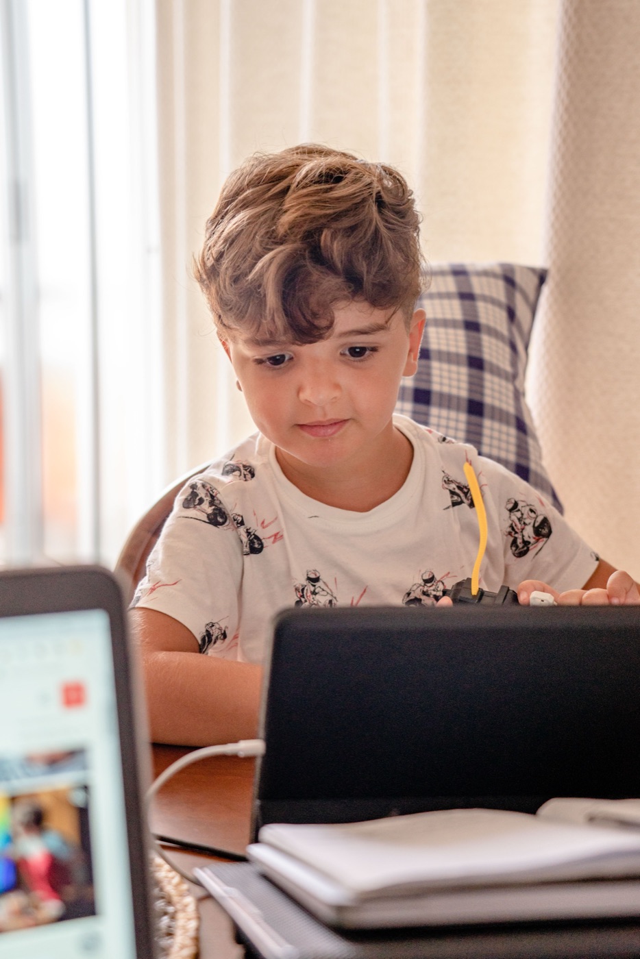 A boy concentrating on a screen during a lesson at home