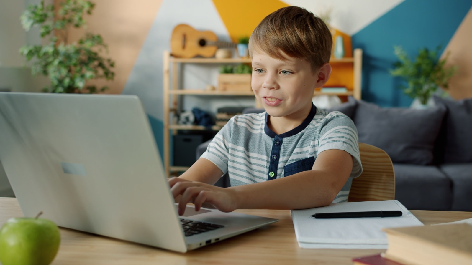 A boy talking to his laptop during an online lesson